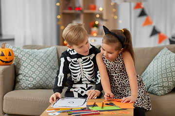 Image showing kids in halloween costumes doing crafts at home