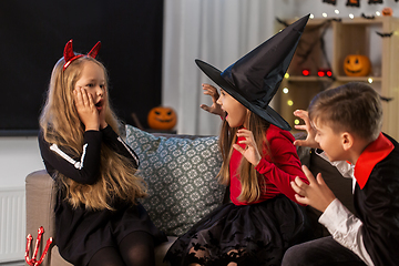 Image showing kids in halloween costumes playing at home