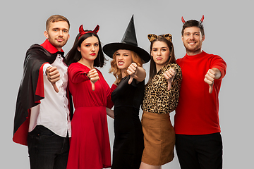 Image showing friends in halloween costumes snow thumbs down