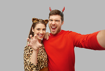 Image showing happy couple in halloween costumes taking selfie