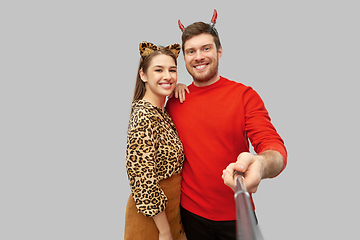 Image showing happy couple in halloween costumes taking selfie