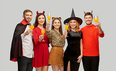 Image showing happy friends in halloween costumes over grey