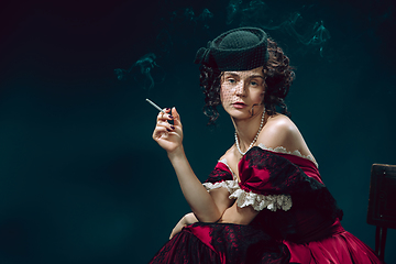 Image showing Young woman as Anna Karenina on dark blue background. Retro style, comparison of eras concept.