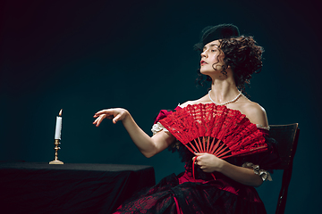 Image showing Young woman as Anna Karenina on dark blue background. Retro style, comparison of eras concept.