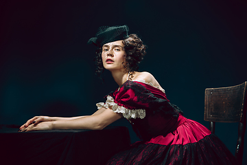 Image showing Young woman as Anna Karenina on dark blue background. Retro style, comparison of eras concept.