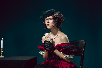 Image showing Young woman as Anna Karenina on dark blue background. Retro style, comparison of eras concept.