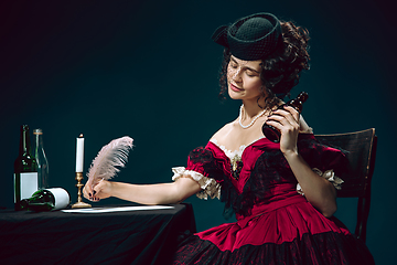 Image showing Young woman as Anna Karenina on dark blue background. Retro style, comparison of eras concept.