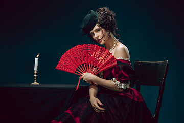 Image showing Young woman as Anna Karenina on dark blue background. Retro style, comparison of eras concept.