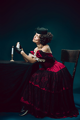 Image showing Young woman as Anna Karenina on dark blue background. Retro style, comparison of eras concept.