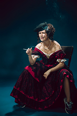 Image showing Young woman as Anna Karenina on dark blue background. Retro style, comparison of eras concept.