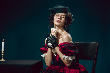 Image showing Young woman as Anna Karenina on dark blue background. Retro style, comparison of eras concept.