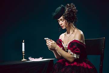 Image showing Young woman as Anna Karenina on dark blue background. Retro style, comparison of eras concept.