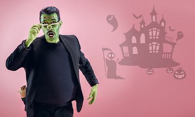 Image showing Young man as a zombie on pink background, halloween time, flyer with copyspace