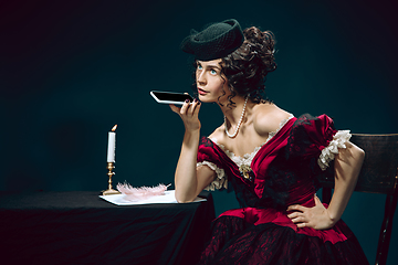 Image showing Young woman as Anna Karenina on dark blue background. Retro style, comparison of eras concept.