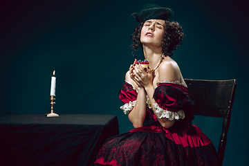 Image showing Young woman as Anna Karenina on dark blue background. Retro style, comparison of eras concept.