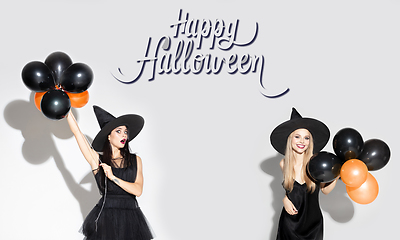 Image showing Young attrective women in hat as a witch on scary background