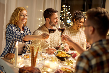 Image showing happy friends drinking red wine at christmas party