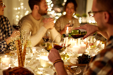 Image showing man pouring red wine into glass at christmas party