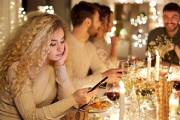 Image showing woman with smartphone at dinner party with friends