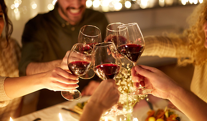 Image showing happy friends drinking red wine at christmas party