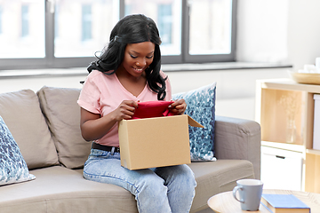 Image showing african american woman opening parcel box at home