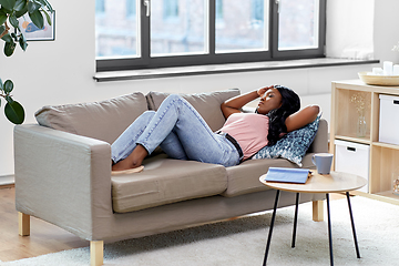 Image showing tired african american woman lying on sofa at home