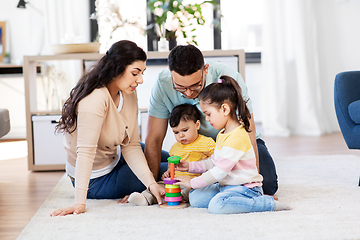 Image showing happy family playing with pyramid toy at home