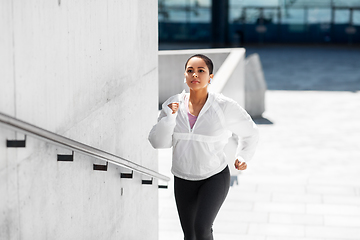 Image showing african american woman running upstairs outdoors