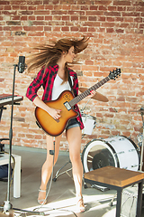 Image showing Woman in headphones recording music, singing or making broadcast internet tutorial while sitting in loft workplace or at home