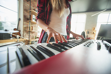 Image showing Woman recording music, singing and playing piano while standing in loft workplace or at home