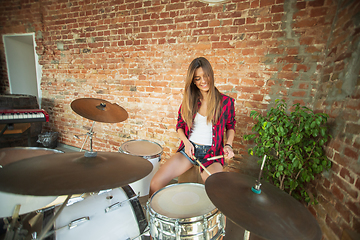 Image showing Woman recording music, singing and playing drums while sitting in loft workplace or at home