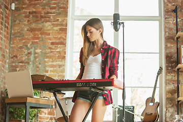 Image showing Woman in headphones recording music, singing or making broadcast internet tutorial while sitting in loft workplace or at home