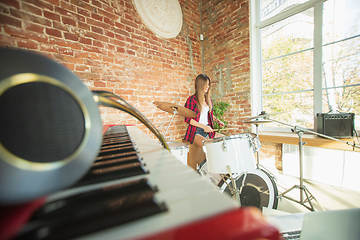 Image showing Woman recording music, singing and playing drums while sitting in loft workplace or at home