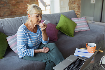 Image showing Senior woman studying at home, getting online courses