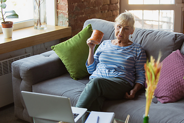 Image showing Senior woman studying at home, getting online courses