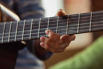 Image showing Senior woman playing guitar, close up hands