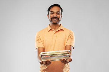 Image showing smiling young indian man sorting paper waste