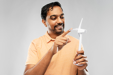 Image showing smiling young man with toy wind turbine