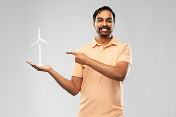 Image showing smiling young man with toy wind turbine
