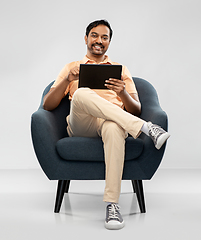 Image showing happy indian man with tablet pc computer in chair