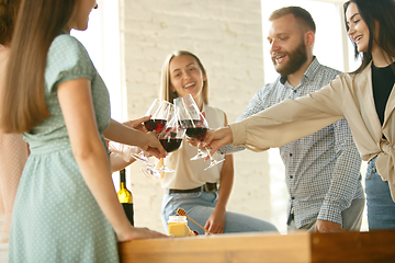 Image showing People clinking glasses with wine or champagne. Happy cheerful friends celebrate holidays, meeting. Close up shot of smiling friends, lifestyle