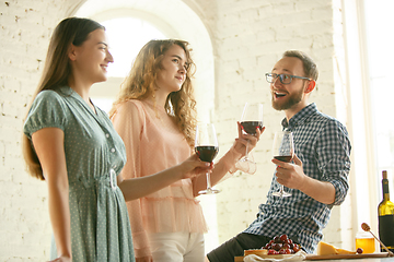 Image showing People clinking glasses with wine or champagne. Happy cheerful friends celebrate holidays, meeting. Close up shot of smiling friends, lifestyle