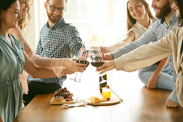 Image showing People clinking glasses with wine or champagne. Happy cheerful friends celebrate holidays, meeting. Close up shot of smiling friends, lifestyle