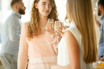 Image showing People clinking glasses with wine or champagne. Happy cheerful friends celebrate holidays, meeting. Close up shot of smiling friends, lifestyle