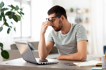 Image showing tired man with laptop working at home office