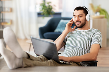 Image showing happy man with laptop and headphones at home