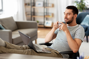 Image showing happy man with laptop drinking coffee at home