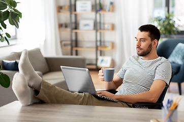 Image showing man with laptop drinking coffee at home