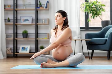 Image showing happy pregnant woman doing yoga at home