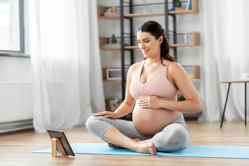 Image showing pregnant woman with tablet pc doing sports at home